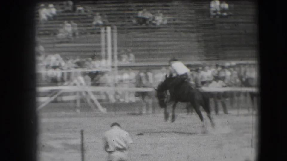 Denver 1941 archival frame showing a horse on the track, a foreground figure, railings, and spectators in stadium seating.