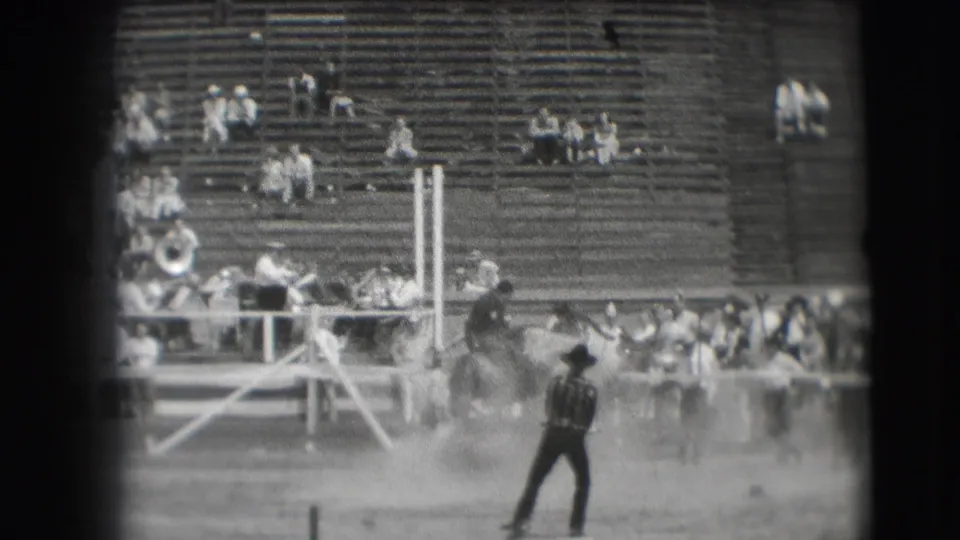 End frame from the 1941 Denver home movie shows dust in the arena near a horse and rider, with an attendant and bleachers visible.