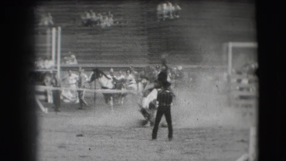 The 1941 home-movie frame shows the horse dipping low in the dusty Denver rodeo ring with an arena figure in the foreground.