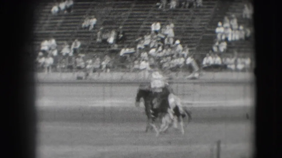 The 1941 Denver rodeo action continues as a rider and bucking horse blur in motion, with spectators watching from the stands.