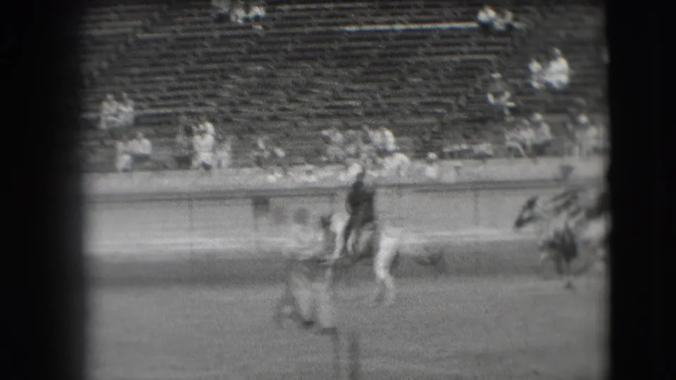Rider on horseback passes near figures in the arena while spectators sit in the bleachers, consistent with the Denver 1941 metadata.
