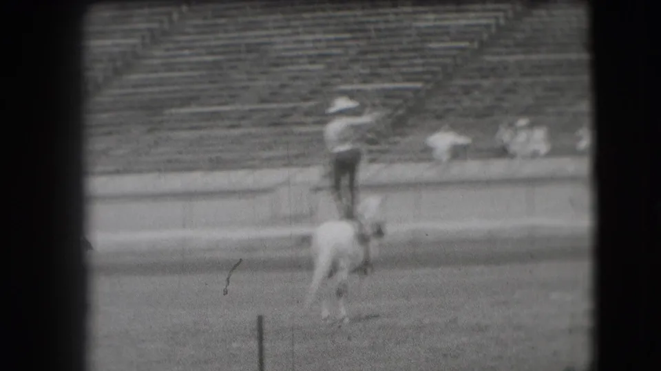 The 1941 Denver home-movie frame shows the performer still balanced on horseback during the lasso routine.