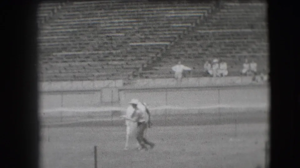 A horse and cowboy move through the open arena, framed by low walls and rows of largely empty Denver stadium seats.