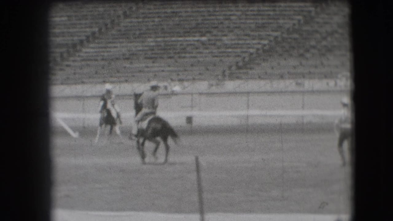 1941 Denver rodeo frame with mounted riders moving through the arena while spectators sit in the background stands.