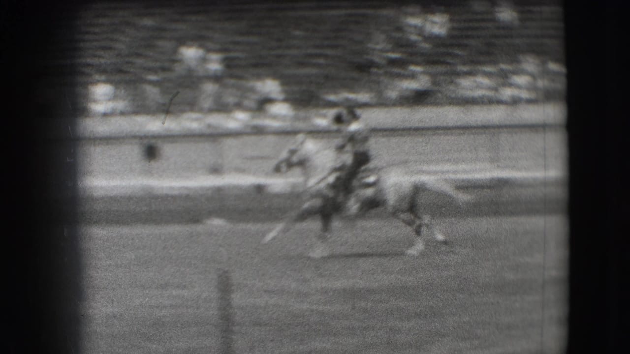 1941 Denver rodeo footage showing a rider on horseback crossing the arena in front of tiered spectator seating.