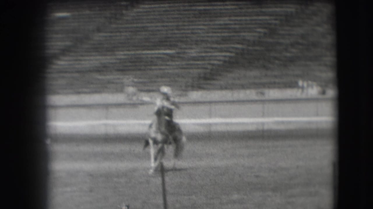 A rider on horseback moves across a large stadium field in archival 1941 Denver home-movie footage.