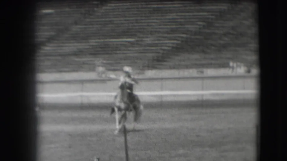 A rider on horseback moves across a large stadium field in archival 1941 Denver home-movie footage.