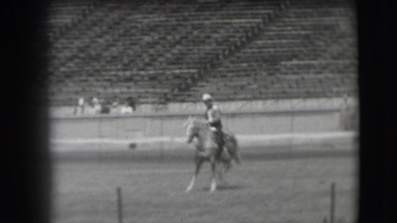 In 1941 Denver footage, a cowboy-style rider on a light horse moves across an open stadium arena with bleachers behind.