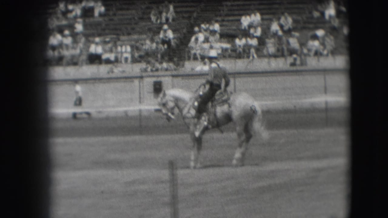 A rider on a light horse appears near the center of the 1941 Denver frame, viewed from a spectator-side home-movie angle.
