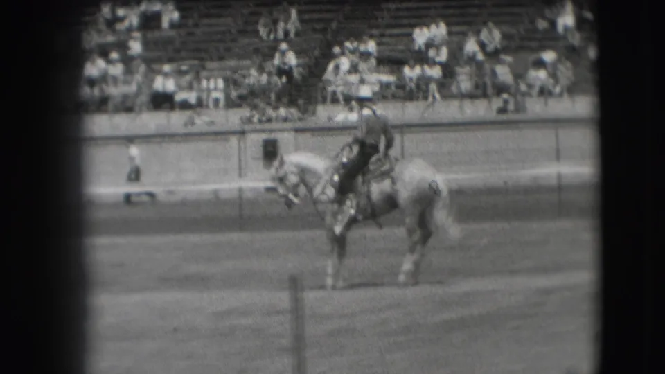 A rider on a light horse appears near the center of the 1941 Denver frame, viewed from a spectator-side home-movie angle.