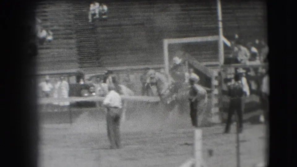 Denver rodeo arena in 1941, showing people gathered near a chute area with wooden bleachers in the background.