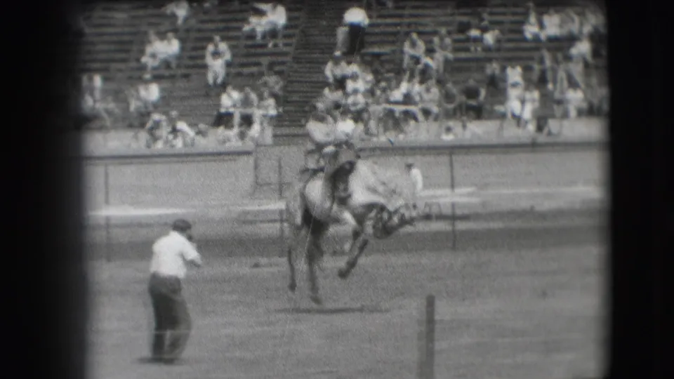 In the supplied 1941 Denver context, a cowboy leans back on a bucking horse while an arena man watches nearby.