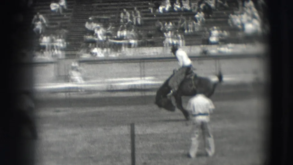The 8mm frame shows the rider lifted as the horse bucks near the bleachers during the 1941 Denver rodeo event.