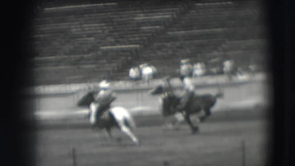 Denver 1941 home-movie footage shows two mounted riders and a pinto horse crossing the field before blurred stadium seating.