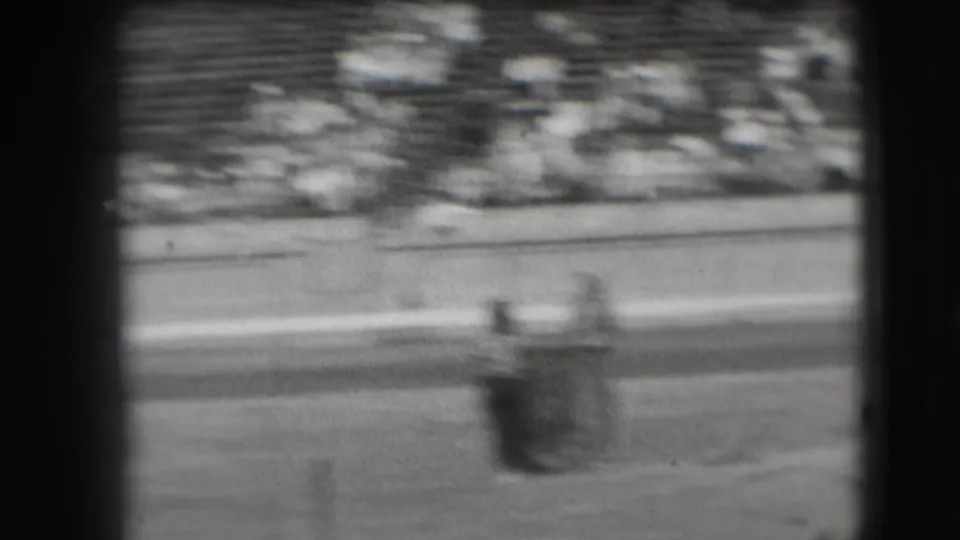 A fast-moving horse and rider blur across the Denver rodeo arena in grainy 8mm footage from 1941.