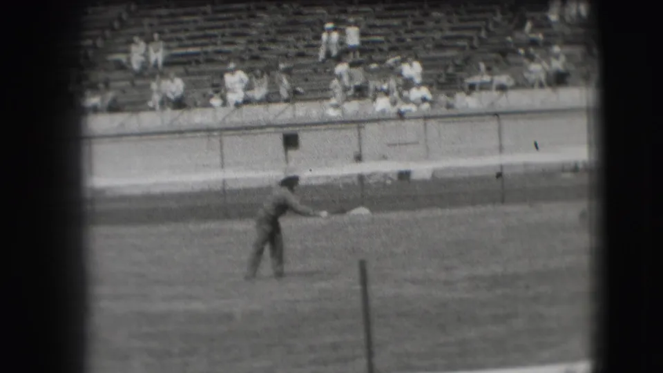 A player appears to release or follow through on a horseshoe throw in the Denver 1941 home-movie footage, with spectators seated beyond the field.