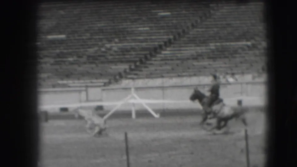 1941 Denver rodeo practice appears to show a mounted rider near a small animal in a large arena with mostly empty bleachers.