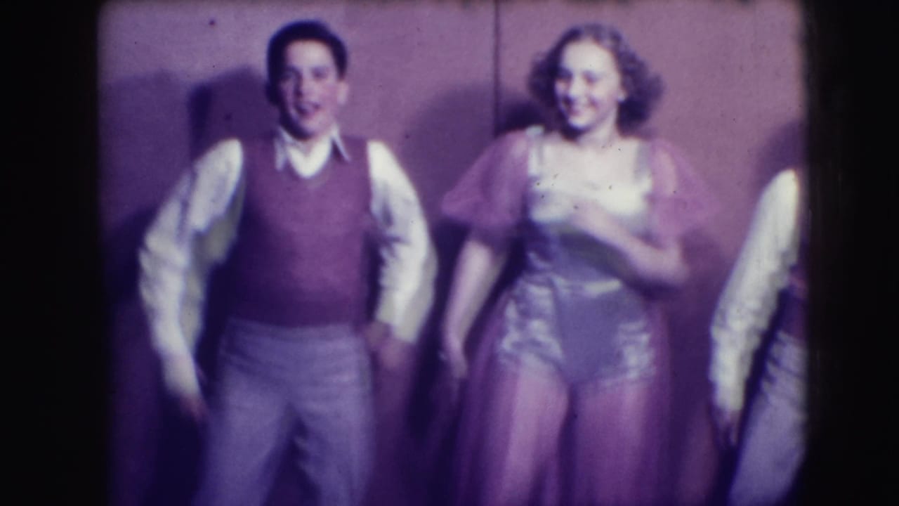 Two boys and a girl perform in front of a plain backdrop.