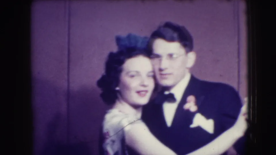 A 1941 Joliet frame captures the woman smiling near the camera as the man in formal wear looks beside her.