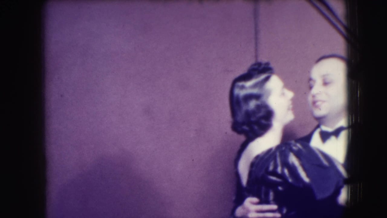 Couple in formal wear dances closely against a purple backdrop.