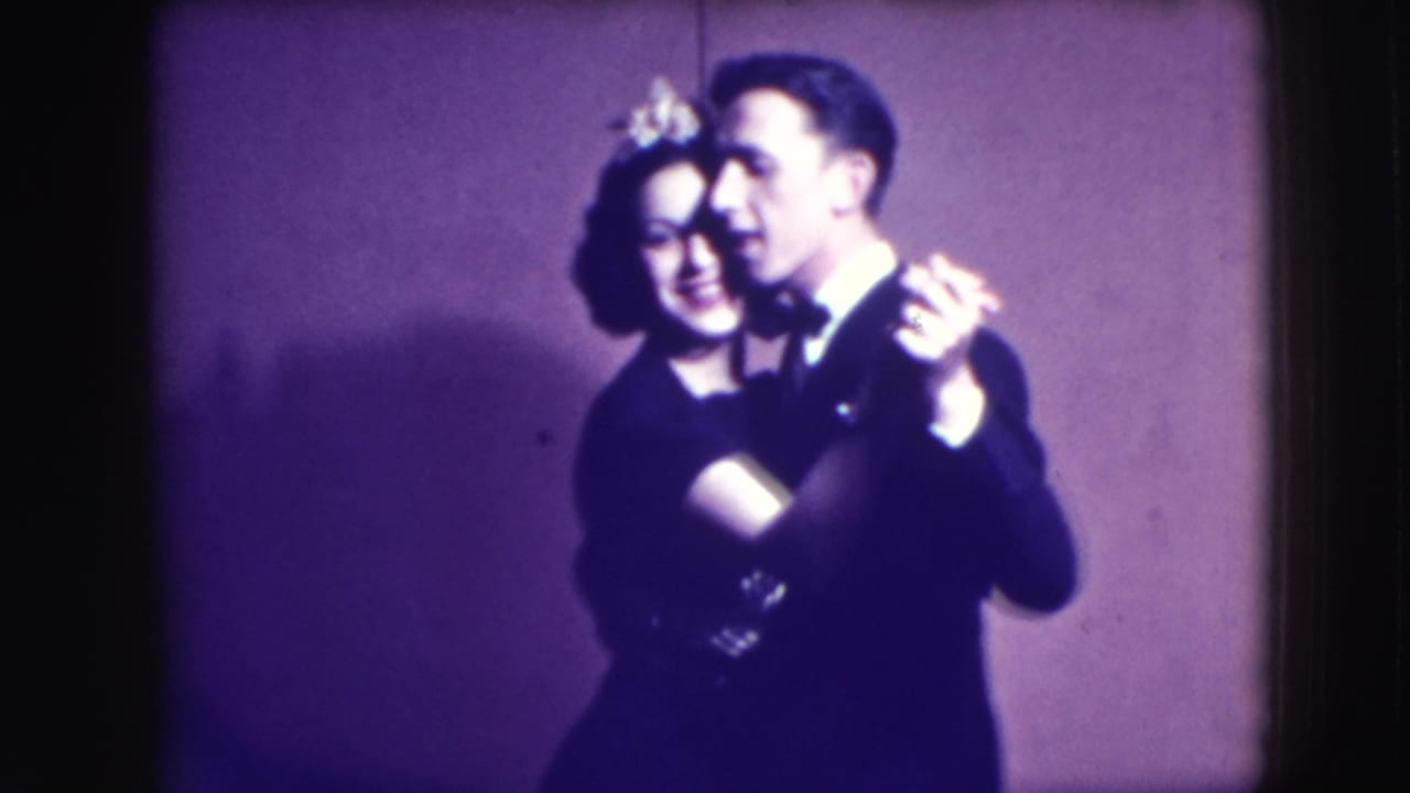 Couple dancing close together against a purple backdrop.