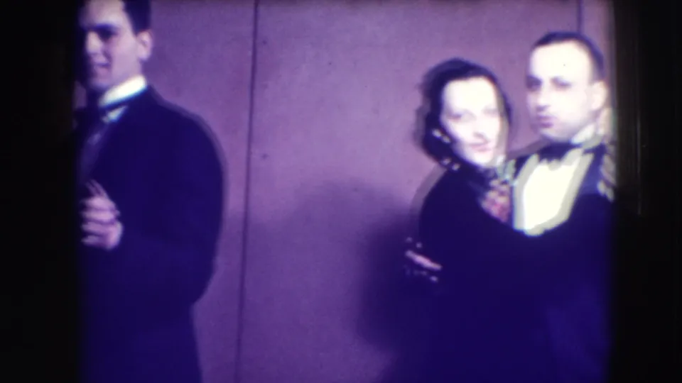 A man in a tuxedo is partly cropped at left while another formally dressed couple appears near the center of the Joliet nightclub frame.