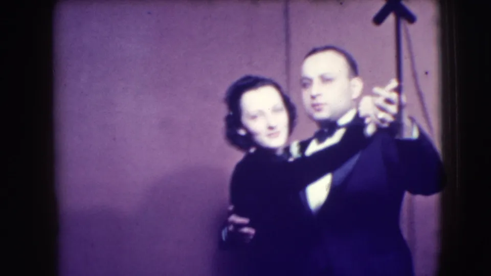 An adult couple in formal wear holds a slow-dance pose in the supplied 1941 Joliet, Illinois home-movie clip.