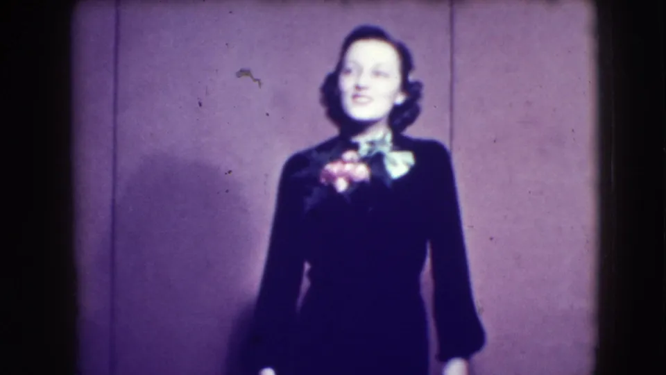 A 1941 Joliet frame shows a woman in dark formalwear with a bright bow or corsage, posed in front of a plain paneled wall.