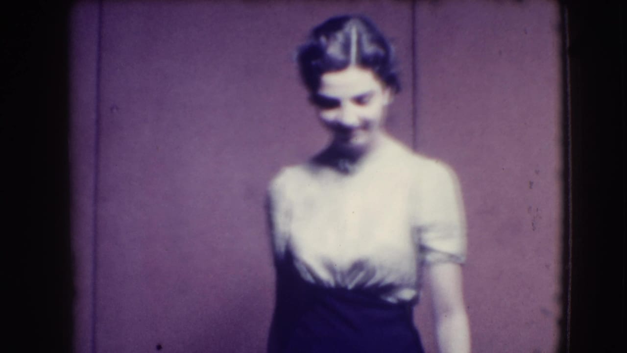 Young woman in light blouse and dark skirt posing against a purple backdrop.