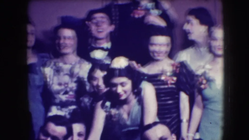 A crowded 1941 Joliet party shot shows guests leaning into the 8mm frame, including women in gowns and a tuxedoed man.