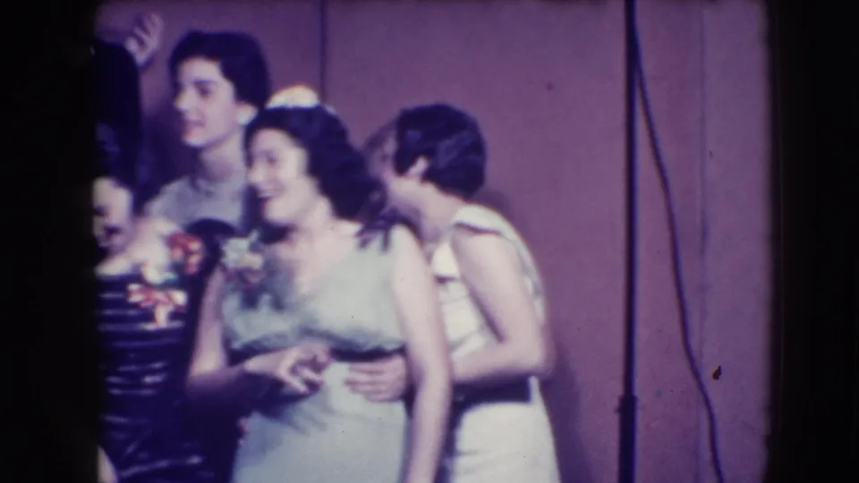Joliet 1941 prom scene with young women in pale gowns and corsages smiling beside a tuxedoed young man.