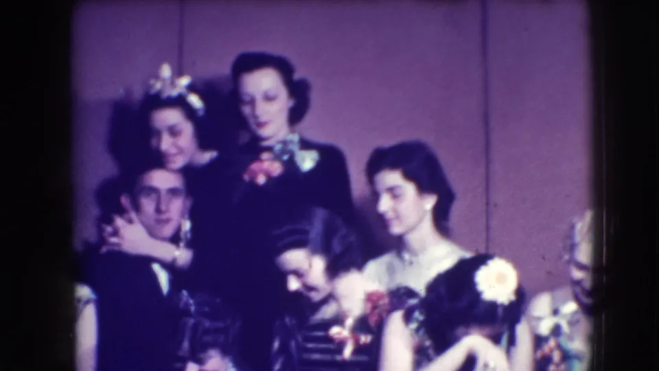 Joliet 1941 prom footage showing a formal group pose with young women, a tuxedoed young man, corsages, and flowers.