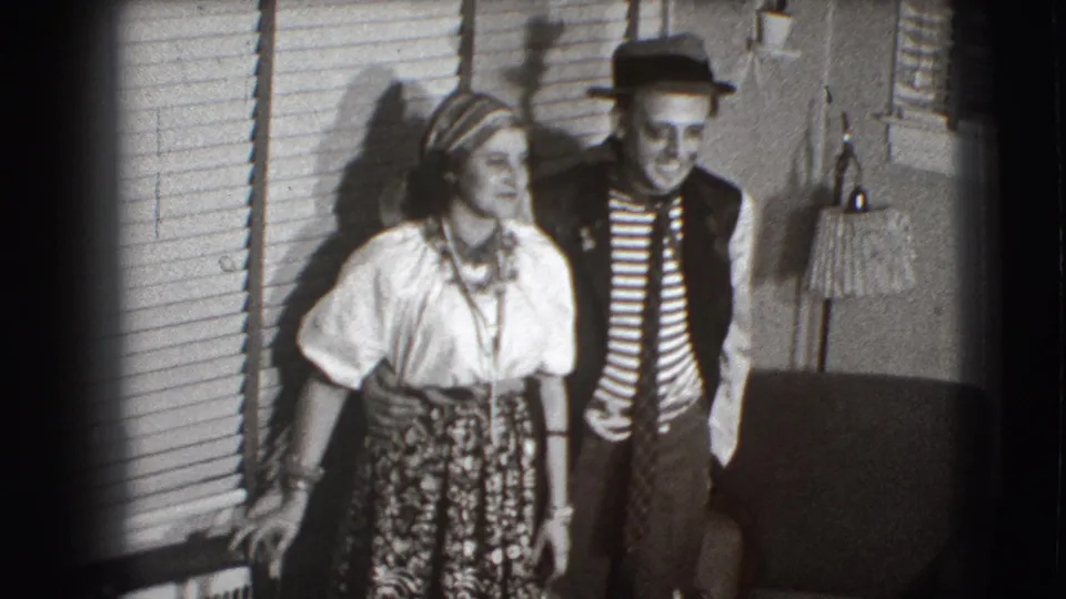 The costumed adults continue posing in the 1941 Joliet home interior, framed by blinds, a floor lamp, and upholstered furniture.