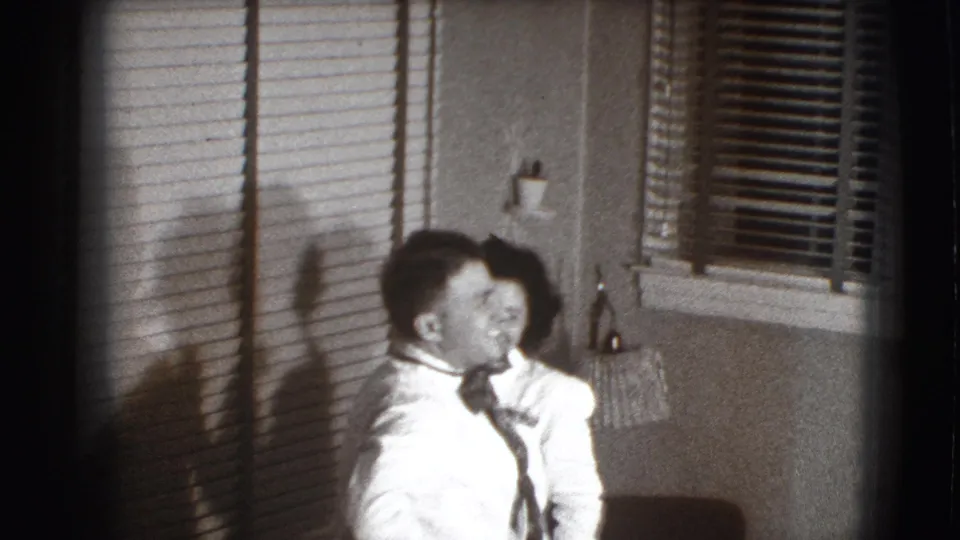 The couple share a close, playful moment as the woman works on the man's tie in the Joliet interior.