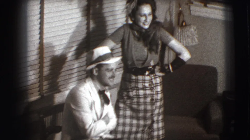 A 1941 Joliet interior frame shows the seated man and standing woman facing the camera in coordinated, posed body language.