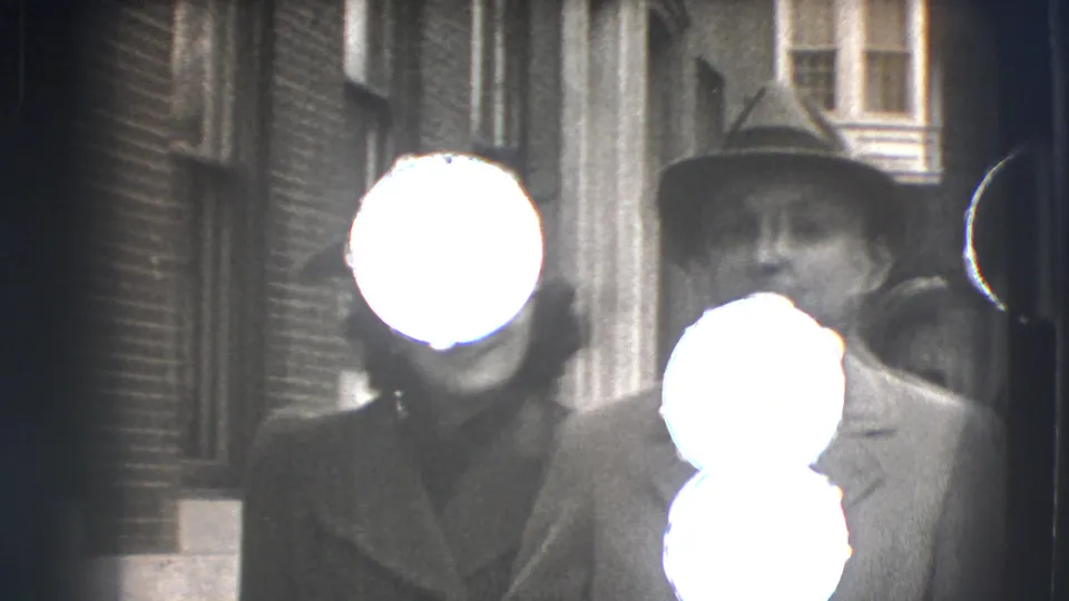The couple nears the camera on a Joliet street, though the faces are partly blown out by exposure in this 8mm frame.