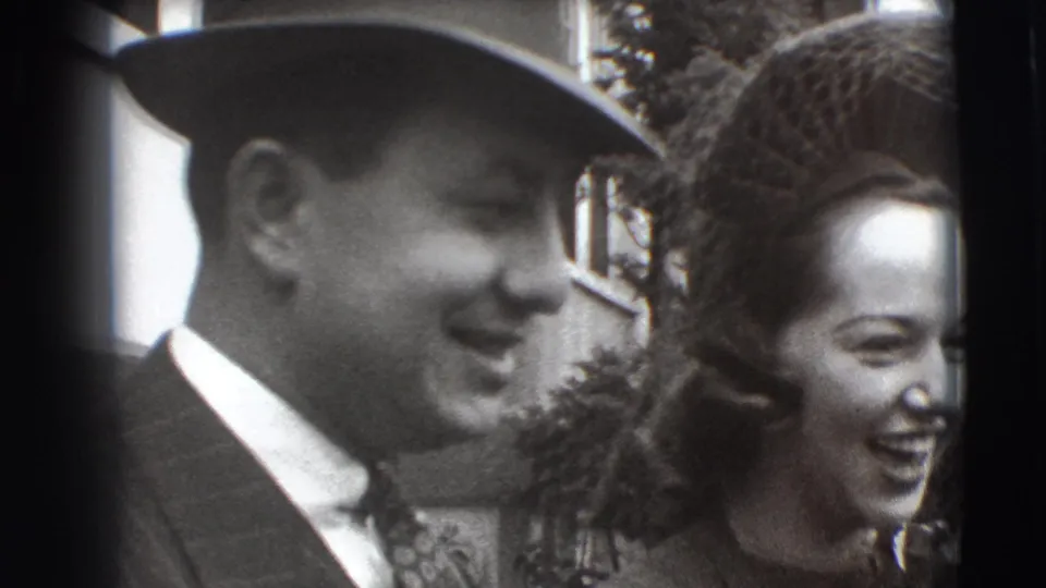 A smiling couple shares a candid moment in 1941 Joliet home-movie footage, with formal clothing and close handheld framing.
