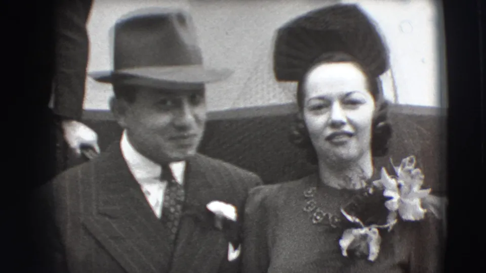 1941 Joliet frame of a suited man in a fedora and a woman with a corsage standing shoulder to shoulder for the camera.