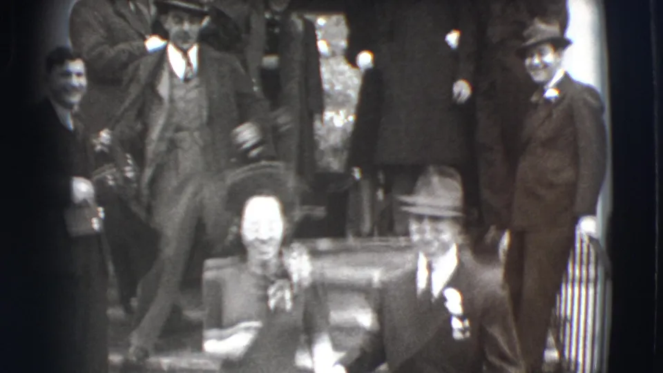 The final frame shows the group spread across the steps, with a woman and a suited man near the lower foreground in soft 8mm focus.