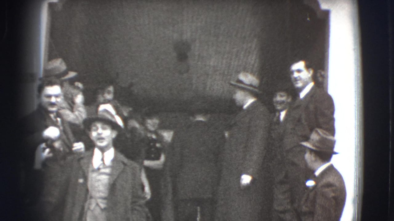 Formally dressed adults stand on steps outside a building, with men in hats and a woman in a fur coat.