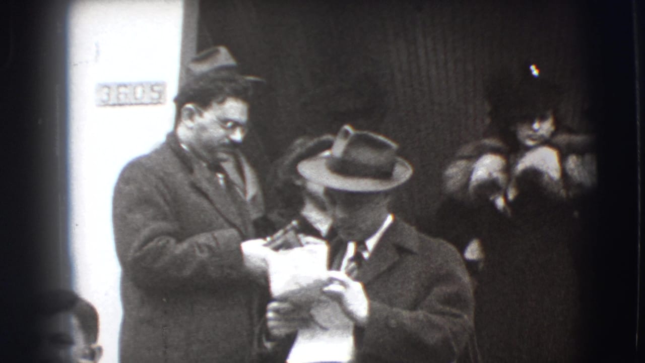 Two men in hats handle papers near a doorway, with a partial sign behind them.