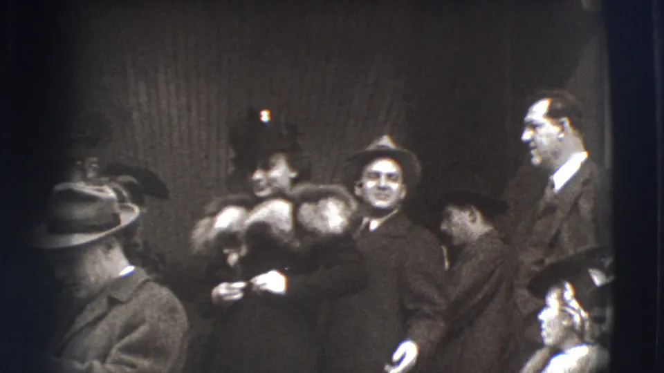 In the final 1941 Joliet frame, adults in formal coats and hats stand close together, with a smiling woman wearing fur near the center.
