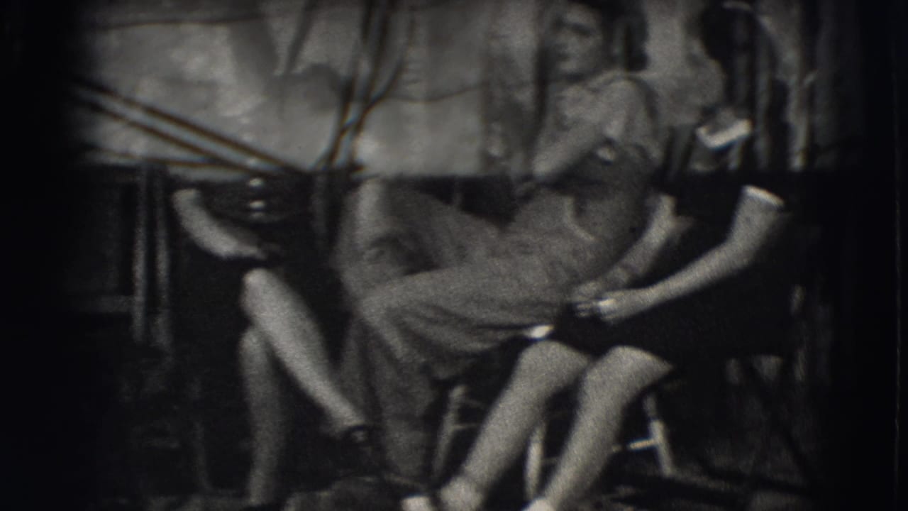 Three young women seated outdoors in a dim backyard or courtyard setting.