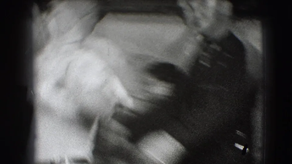 Soft, blurred 1941 8mm frame from Joliet showing two adults close together during a theatrical rehearsal moment.