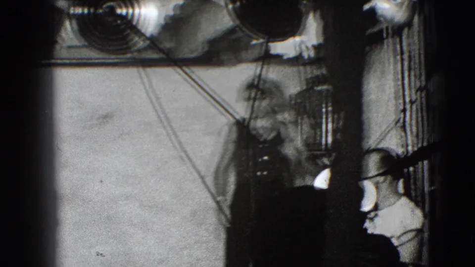 The costumed performer appears blurred in motion beneath overhead fixtures and cables during the 1941 Joliet theatrical rehearsal.