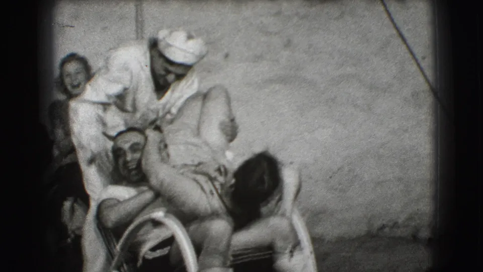 In the 1941 Joliet footage, a capped man leans over a seated man in a wheelchair while a woman smiles in the background.