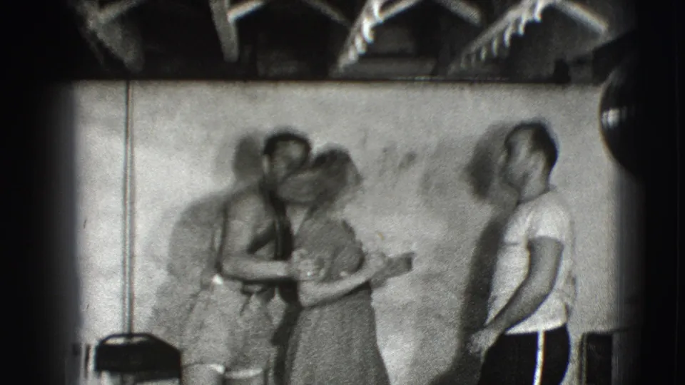 The couple appears mid-twirl in blurred 8mm motion, with another adult standing nearby in the 1941 Joliet scene.