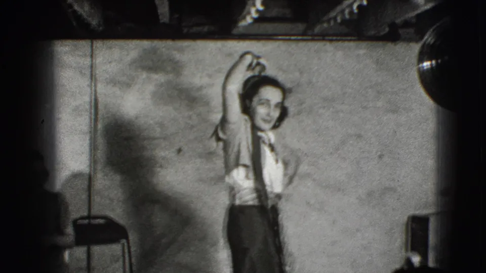 In Joliet, Illinois 1941 home-movie footage, a young woman poses or dances with one arm raised in a plain indoor room.