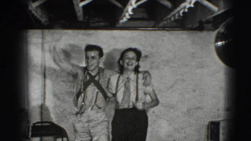 Two men, one possibly in a military-style shirt, pose playfully with an arm raised in the same 1941 Joliet home-movie setting.