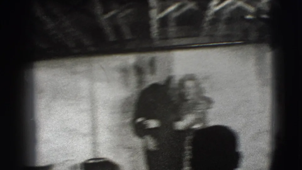 A blurred frame from the 1941 Joliet home movie shows the couple moving together inside a dim room.